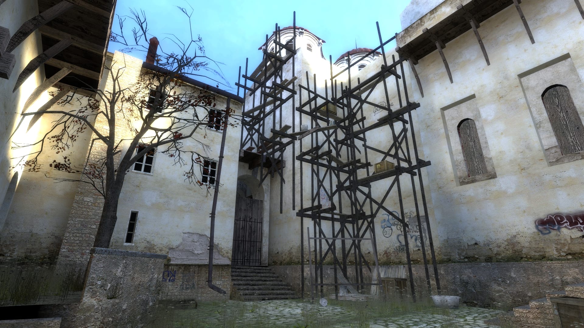 A screenshot of the game, just outside the monastery. It features a bunch of scaffolding right outside the historic building, along with some crates and graffiti.