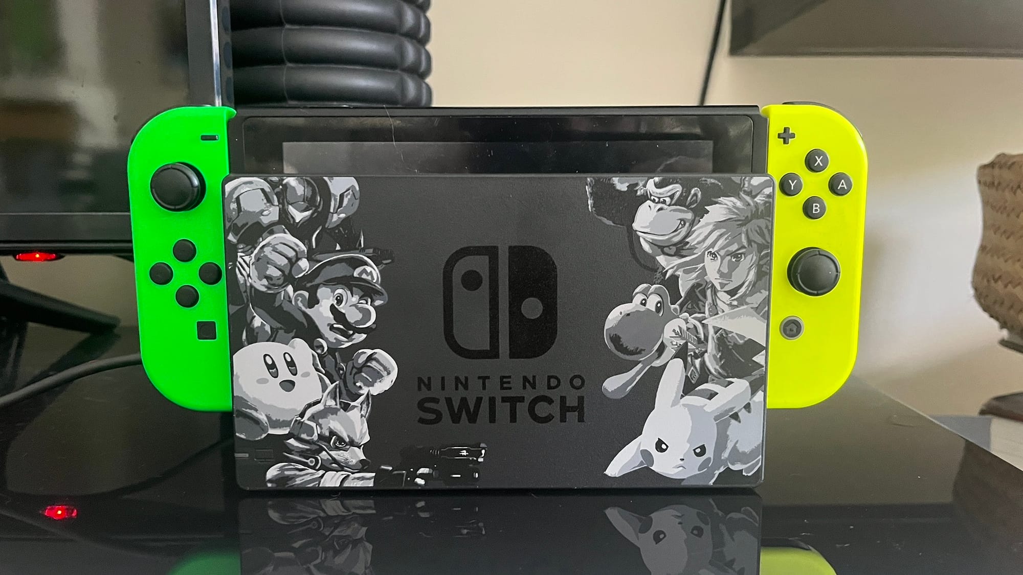 A Nintendo Switch with Green and Yellow joycons, docked in the Super Smash Bros Ultimate edition dock.