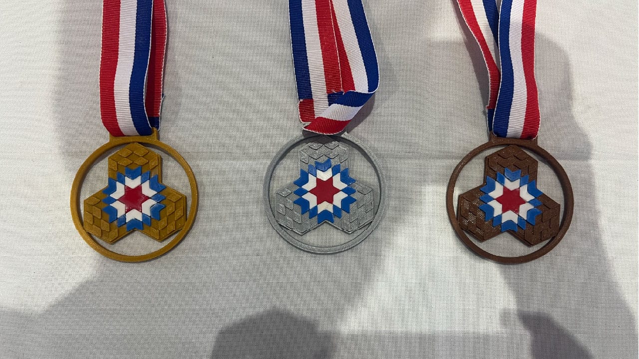 The gold, silver, and bronze medals for Santo Domingo Winter 2026. They are 3D printed and feature the logo for the competition in the design.
