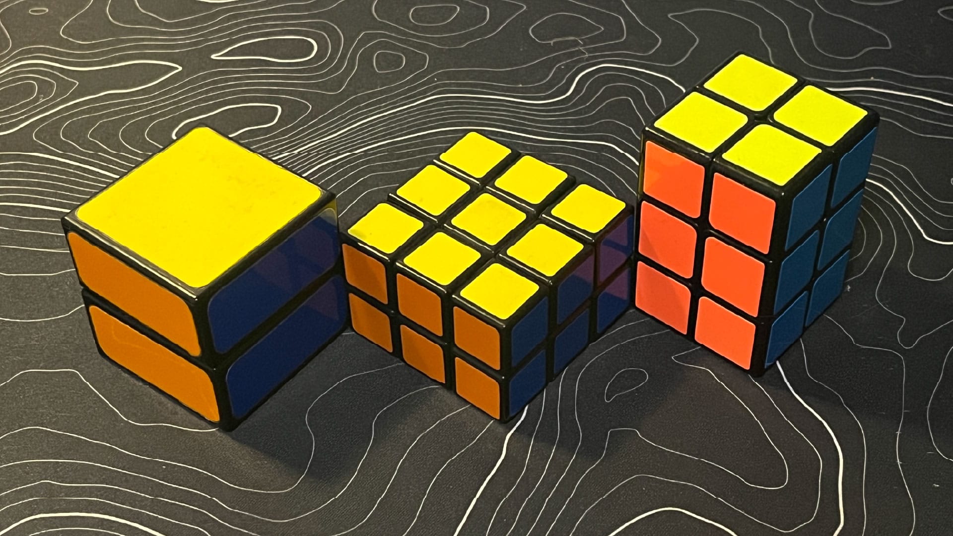A Boob Cube (1x1x2), LanLan 3x3x2, and QiYi 2x2x3.