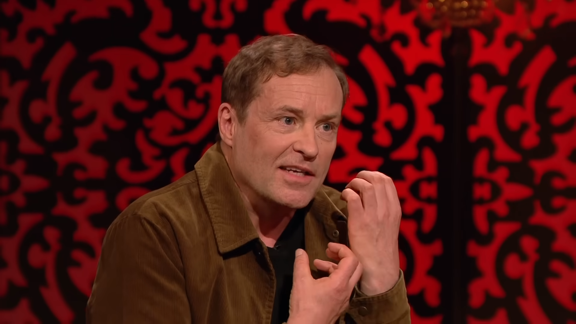 Screenshot of Taskmaster UK S13 E6. Ardal O'Hanlon is miming holding a tea towel.