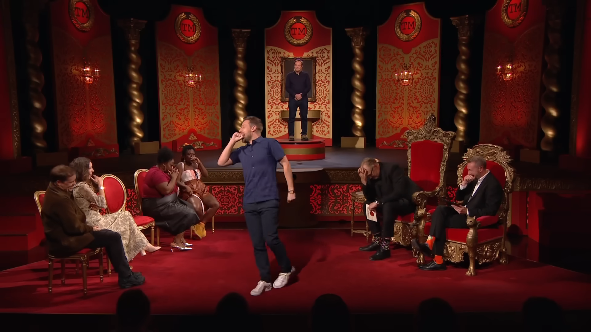 Screenshot of Taskmaster UK S13 E6. After Ardal O'Hanlon wasn't able to ask a question within a time limit Judi and Greg are facepalming, Bridget, Sophie, and Alex are covering their mouths, and Chris stood up in disbelief.