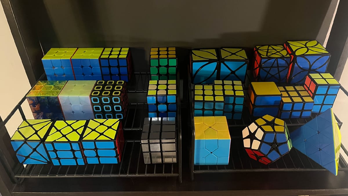 The bottom shelf of my cube collection, containing some 3x3s and other puzzles.