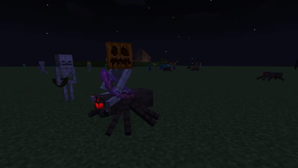 A screenshot from Minecraft, highlighting a Spider Jockey wearing a pumpkin on its head. Other zombies and skeletons are in the background also wearing pumpkins, including one with a Jack O'