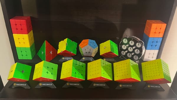 The top shelf of my cube collection. Featuring my mains for 2x2 – 7x7, Pyramind, Skewb, Megaminx, Square-1, and Clock.